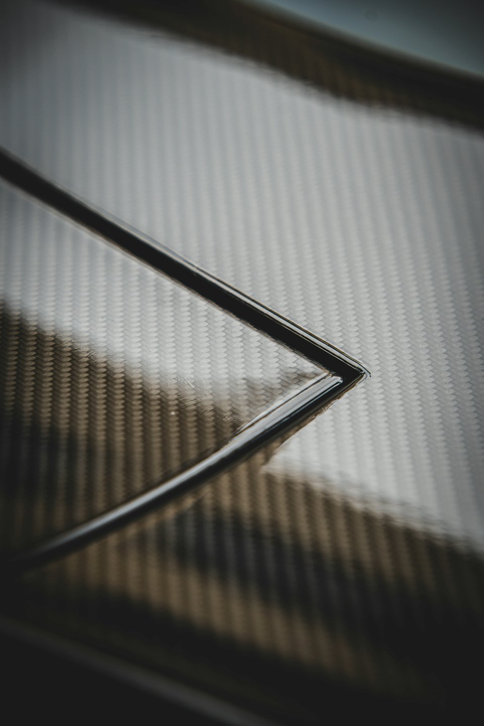 Intricate black carbon fiber weave with a sharp corner.